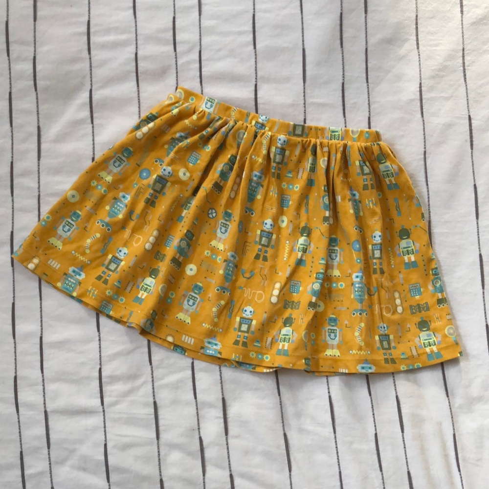 Awesome robot twirly skirt. Green, blue, yellow on a goldenrod background.